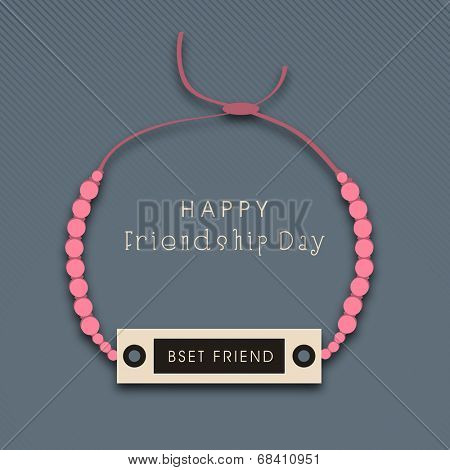 Friendship band with pink pearls on grey background for Happy Friendship Day celebrations. 