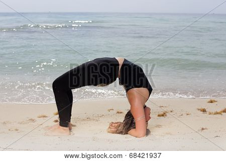 Woman in a Setu Bandha Sirsasana yoga pose