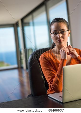 beautiful young woman relax and work on laptop computer while listening music on heaphones and read book at home