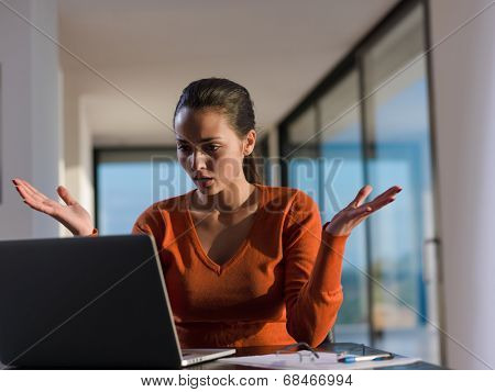 beautiful young woman relax and work on laptop computer while listening music on heaphones and read book at home