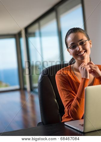 beautiful young woman relax and work on laptop computer while listening music on heaphones and read book at home