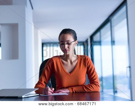 beautiful young woman relax and work on laptop computer while listening music on heaphones and read book at home