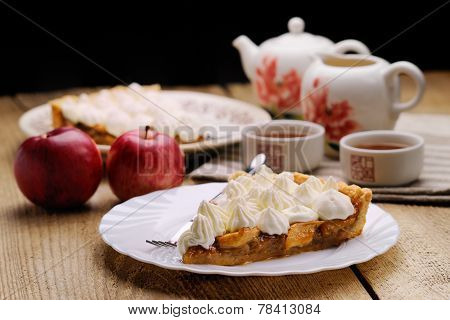 Piece Of Cake Decorated With Whipped Cream With Teaware And Apples Side View