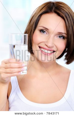 Donna sorridente tiene un bicchiere di acqua pulita