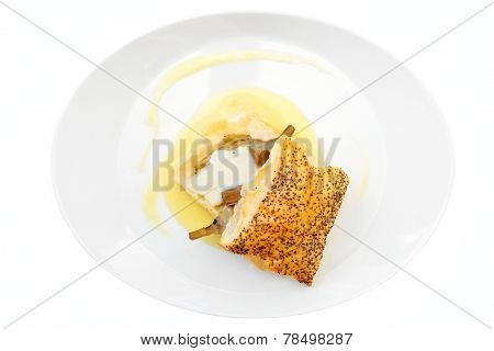 Bun with braised artichoke on oval plate isolated on white background