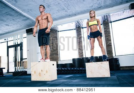 Group of man and woman workout with fit box at gym