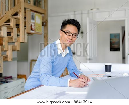 Young chineese engineer working in office
