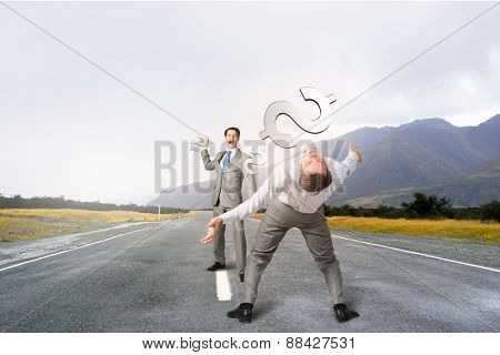 Young businessman benting to evade from thrown dollar sign