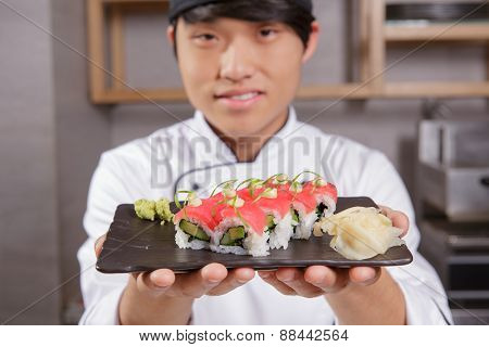 Cook stretches out a plate with sushi