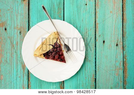 Little Piece Of Homemade Vegan Wholegrain Galette With Cherries With Fork In White Plate On Turquois