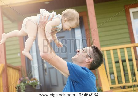 father and daughter play in front of the house