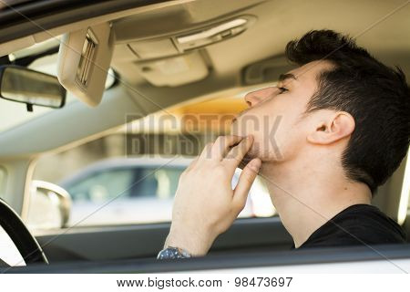 Man Looking at his Pimple Using Mirror of a Car