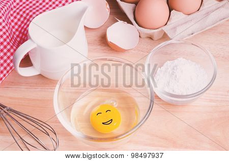 Cookies ingredients. Bowl, flour, eggs, jar of milk, eggbeater,eggshells and red napkin