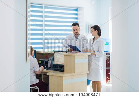 Busy reception in a hospital with doctors and receptionists.