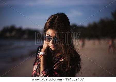 young stylish happy hipster woman traveling around the world wearing aviator sunglasses, denim shirt, tropical island lagoon vacation.