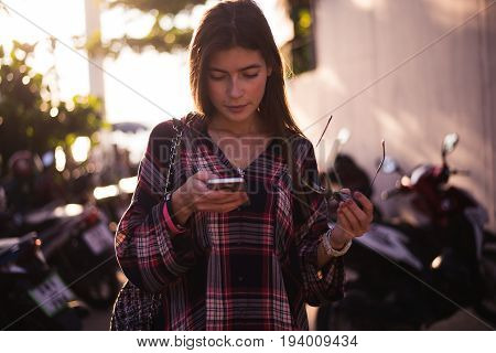 young stylish happy hipster woman traveling around the world wearing aviator sunglasses, denim shirt, tropical island lagoon vacation.