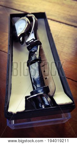 stylish lades hand watch in box on dark shed wood background