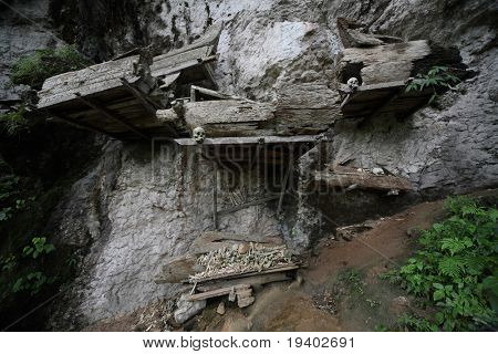 Régi családi koporsók, a csontok egy sziklán lógó csoportjai. Tana Toraja régió. Sulawesi sziget. Indo