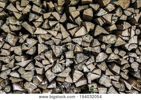 Abstract photo of a pile of natural wooden logs background dry chopped firewood logs ready for winter