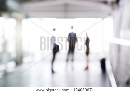 Blurred business people standing in building hall can be used as abstract background