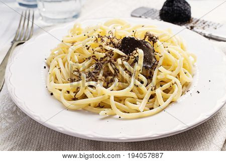 Strangozzi italian wheat pasta with truffle on a light background.