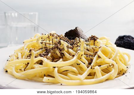 Strangozzi italian wheat pasta with truffle on a light background.