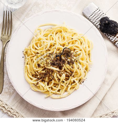 Strangozzi italian wheat pasta with truffle on a light background.