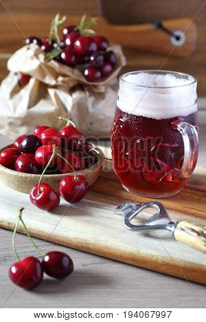 Light fruit craft beer and cherry on wooden chopping board rustic style
