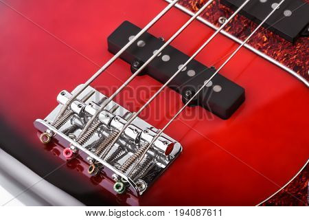 Metallic volume treble guitar bass knobs. Electric guitar. Red electric bass guitar close-up. Musical instrument. Music. Four strings. Grif.