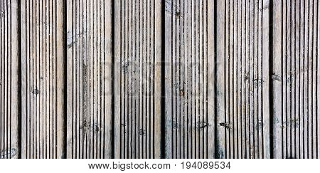 Old weathered wood planks outside flooring teak texture background. Wooden pattern of antique ribbed wooden planks for construction deck or indoor floor.