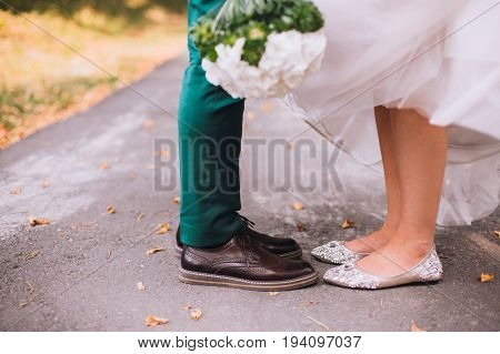 Leg and shoes of wedding couple outdoor