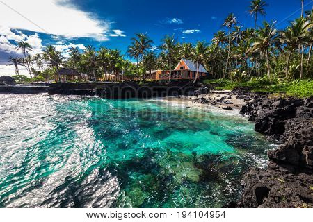 Coral reef and small beach with palm trees on south side of Upolu, Samoa Islands.