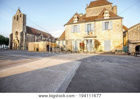 Sunset view on the old church and town hall in Domme village in France