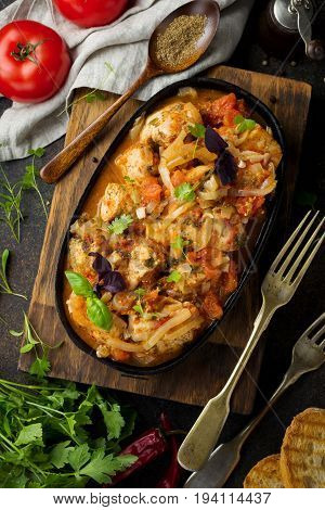 Chakhokhbili - traditional Georgian dish. Stewed chicken with tomato onion garlic pepper and cilantro. Selective focus. Top view.