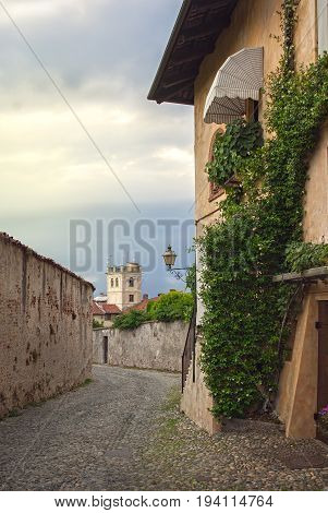 Narrow paved street among old historic houses in Saluzzo, northern Italy.