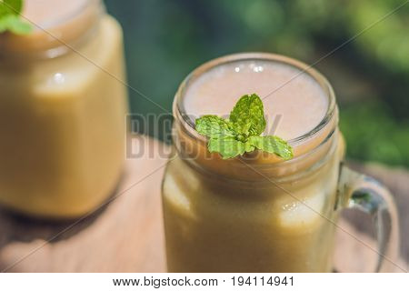 Banana Smoothies And Bananas On An Old Wooden Background