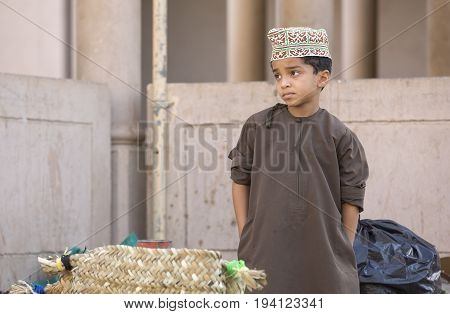 Nizwa Oman June 23rd 2017: omani boy in traditional clothing at a market