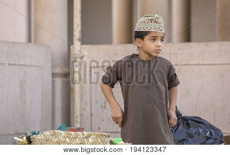 Nizwa Oman June 23rd 2017: omani boy in traditional clothing at a market