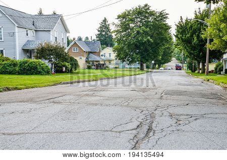 Kane USA - July 21 2014: Residential neighborhood in city with rough roads and streets and houses