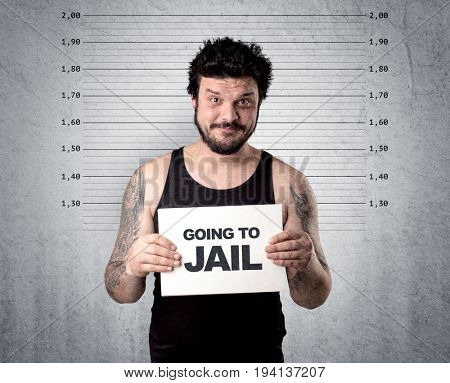 Caugth offender in front of a wall with table in his hand.