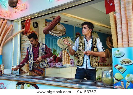 ISTANBUL TURKEY - MAY 2 2017: Young dondurma ice-cream sellers dressed in traditional Turkish costume in the street shop