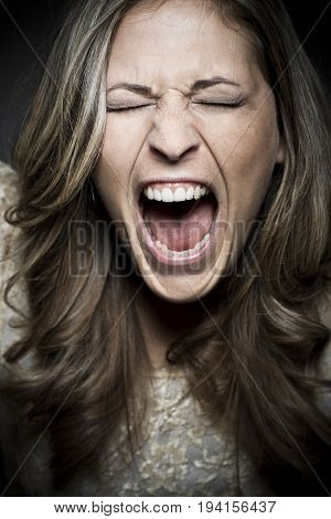 A woman screams loud with closed eyes