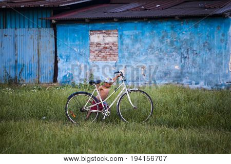 Cluj-Napoca, Romania - 27 June 2017: Unidentified child carrying a bicycle in the isolated poor romani community of Pata Rat, the rubbish dump near Cluj-Napoca, Romania