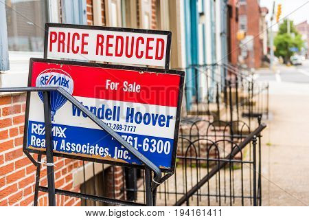 Harrisburg USA - May 24 2017: Pennsylvania capital city houses with Re Max for sale price reduced sign in downtown by sidewalk street