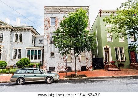 Frederick USA - May 24 2017: Maryland downtown city with entrance door to old white brick house and sidewalk with cars in residential neighborhood
