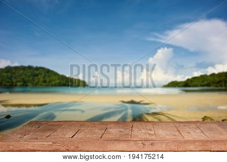 Empty Top of wood table with blurred sea and beach background. For Product display montage. Beach in summer Concept.