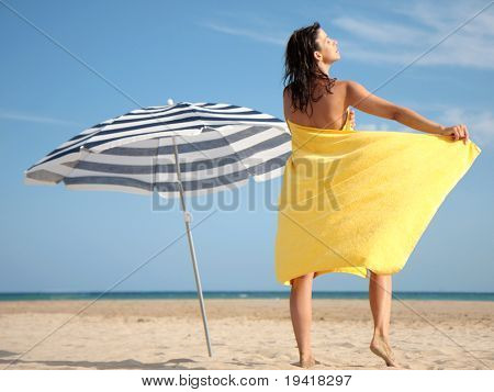Kobieta z ręcznikiem na plaży podczas opalania