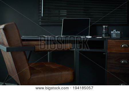 Work space on black table of a photographer or designer with laptop retro camera Stylish home studio concept of hipster . Seleted focus.