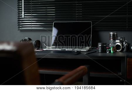 Work space on black table of a photographer or designer with laptop retro camera Stylish home studio concept of hipster . Seleted focus.