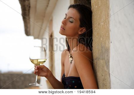Donna seduta sul tetto di un antico edificio con vino